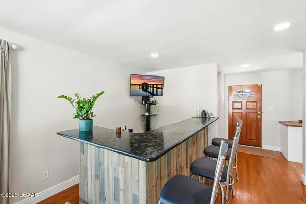 a view of a hallway with furniture and wooden floor