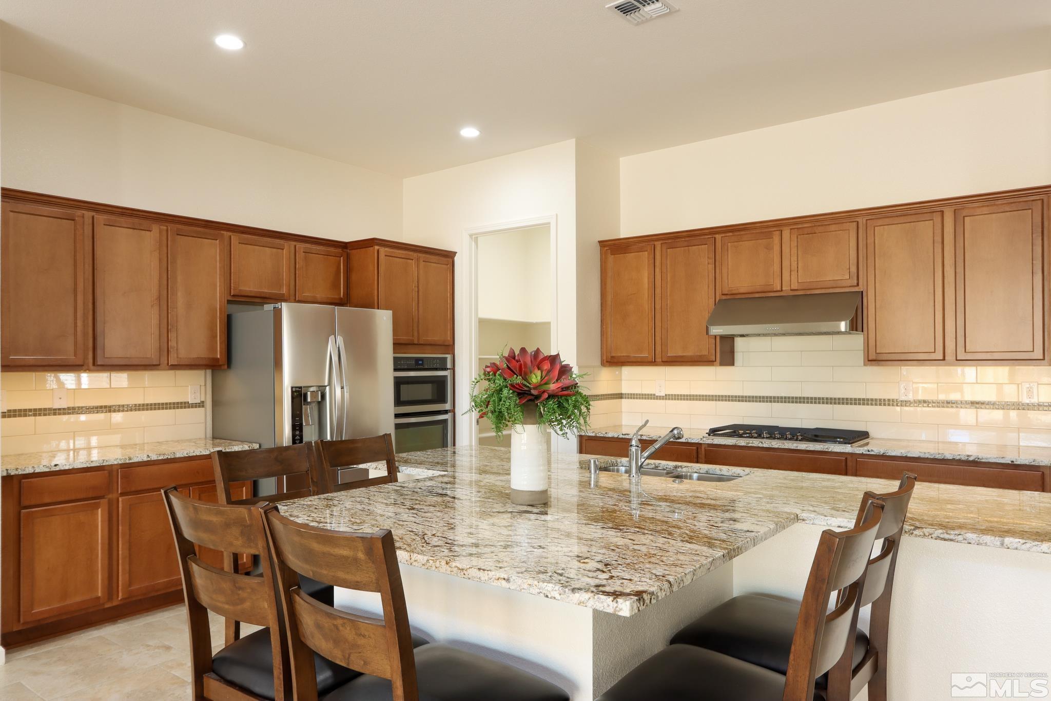 9410 Stony Hill Road Reno, NV 89521 - Photo 15 of 39 a kitchen with stainless steel appliances granite countertop a dining table and chairs