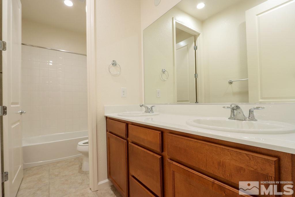 9410 Stony Hill Road Reno, NV 89521 - Photo 31 of 39 a bathroom with a granite countertop sink and a mirror