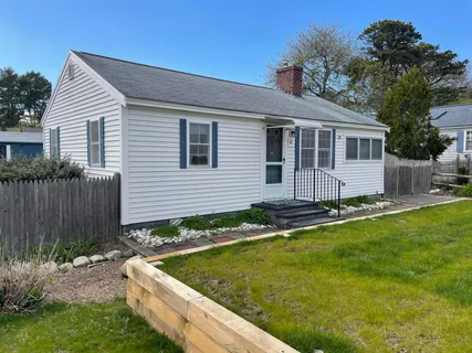 a front view of house with yard and outdoor seating