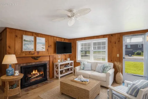 a living room with furniture a fireplace and a flat screen tv