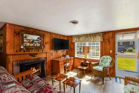 a living room with furniture a flat screen tv and a fireplace