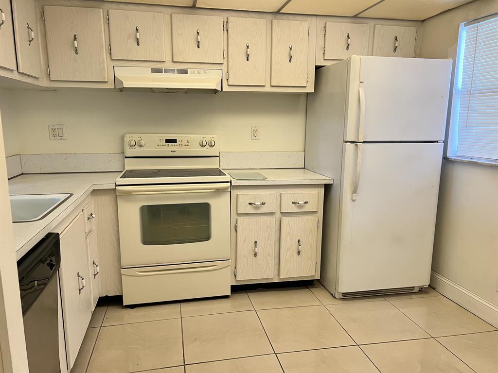 8810 West McNab Road, Unit 205 Tamarac, FL 33321 - Photo 5 of 11 a kitchen with white cabinets and white appliances