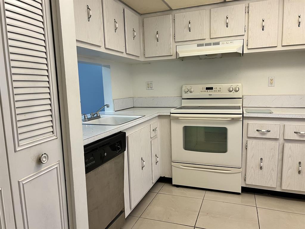 8810 West McNab Road, Unit 205 Tamarac, FL 33321 - Photo 6 of 11 a kitchen with white cabinets and white appliances