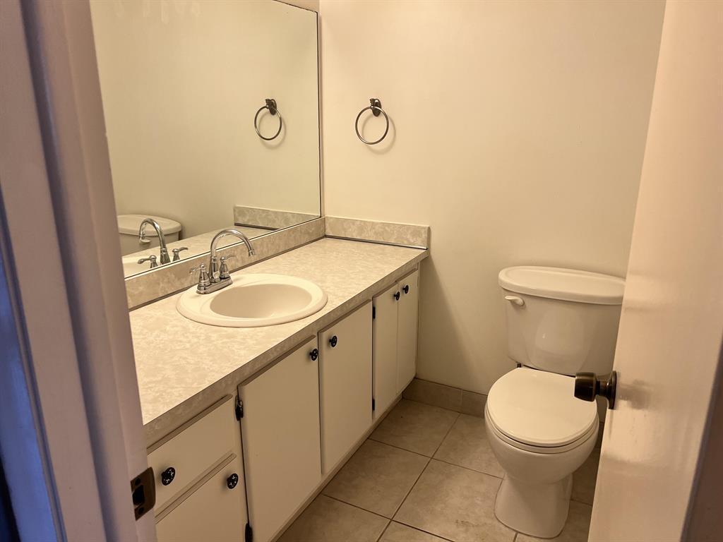 8810 West McNab Road, Unit 205 Tamarac, FL 33321 - Photo 8 of 11 a bathroom with a granite countertop toilet sink and mirror