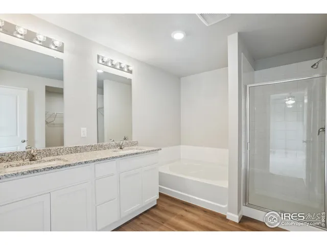 a bathroom with a granite countertop sink a mirror a bathtub and shower
