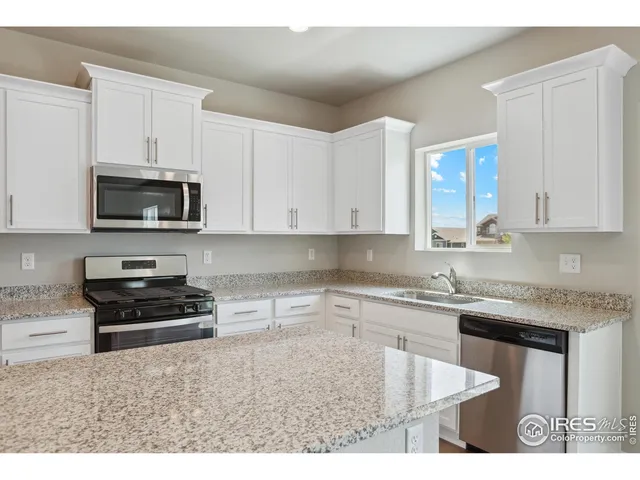 a kitchen with stainless steel appliances granite countertop a stove a sink a microwave and cabinets