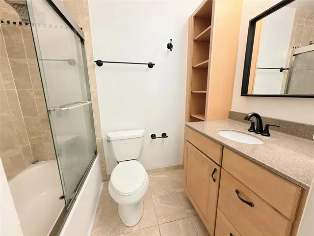 a bathroom with a sink a toilet a mirror and shower