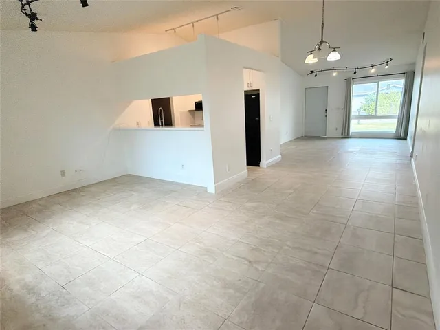 an empty room with kitchen and window