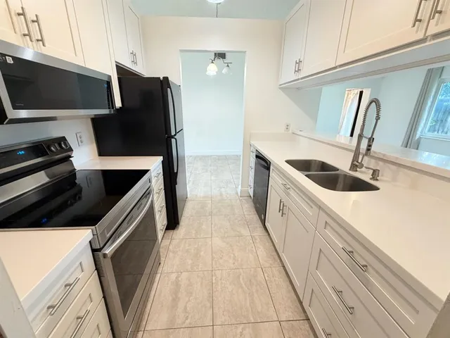 a kitchen with stainless steel appliances a refrigerator a stove a sink and a oven