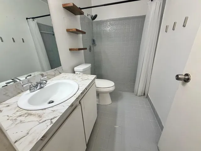 a bathroom with a sink toilet and shower