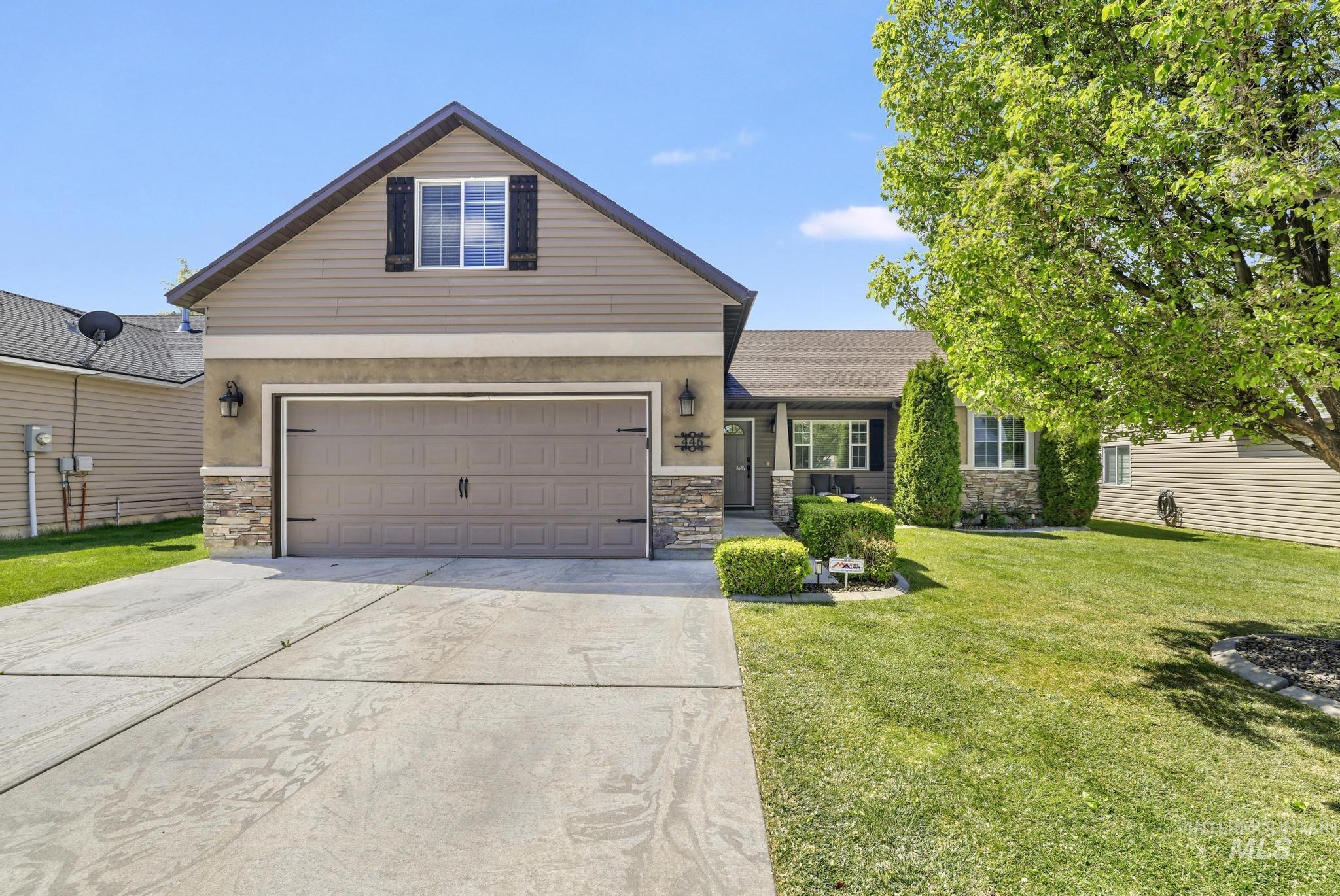 446 Noble Street Twin Falls, ID 83301 - Photo 2 of 42 Property exterior featuring a two-car garage, stone and siding facade, covered entry, and a manicured lawn