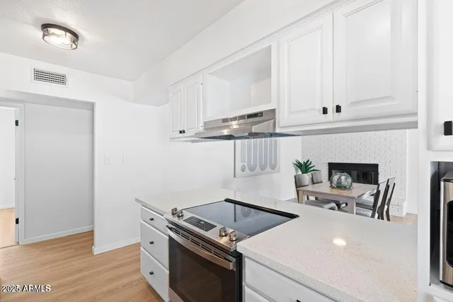 a kitchen with a stove and white cabinets