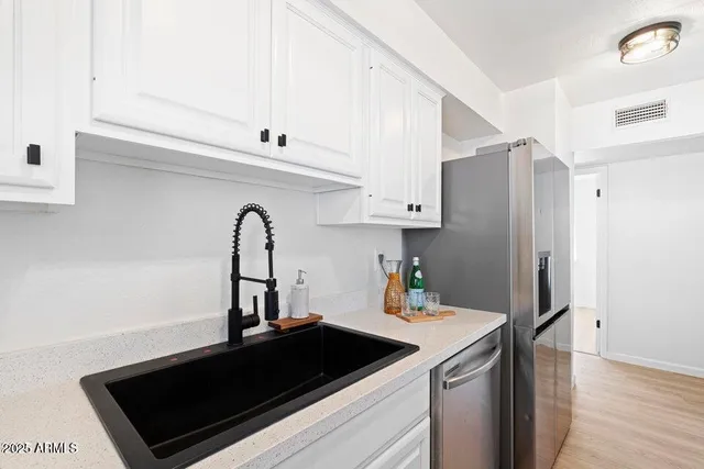 a kitchen with a sink a refrigerator and cabinets