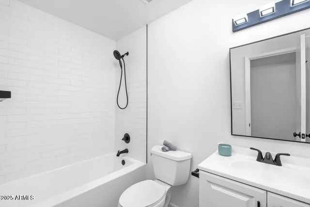 a bathroom with a toilet sink vanity tub and shower