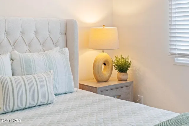 a bedroom with a bed and a painting on the wall