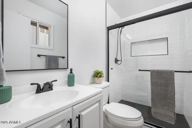 a bathroom with a sink a toilet and shower