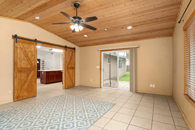a view of a livingroom with a chandelier fan and windows