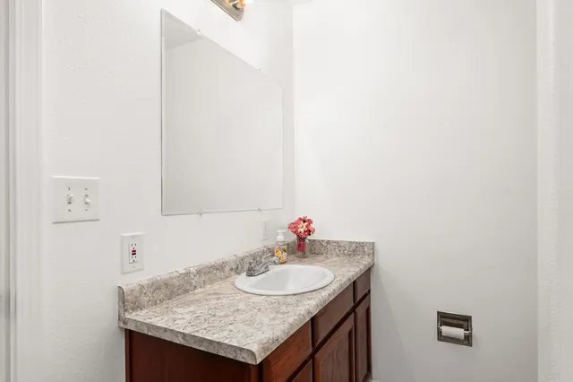 a bathroom with a granite countertop sink and a mirror