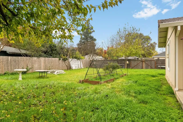 a view of backyard with wooden fence