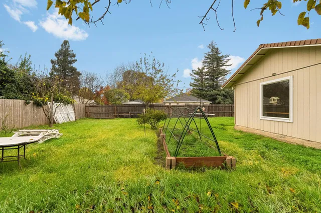 a backyard of a house with table and chairs
