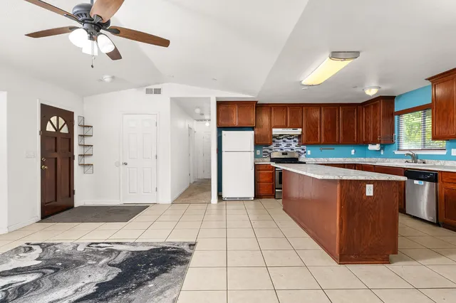 a kitchen with stainless steel appliances granite countertop a refrigerator and a sink