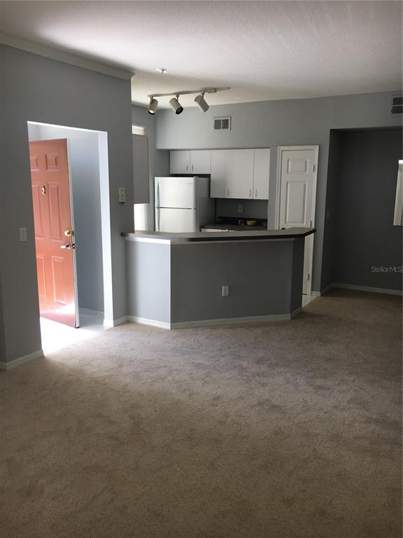 6304 Raleigh Street, Unit 204 Orlando, FL 32835 - Photo 11 of 29 a kitchen with kitchen island and stainless steel appliances