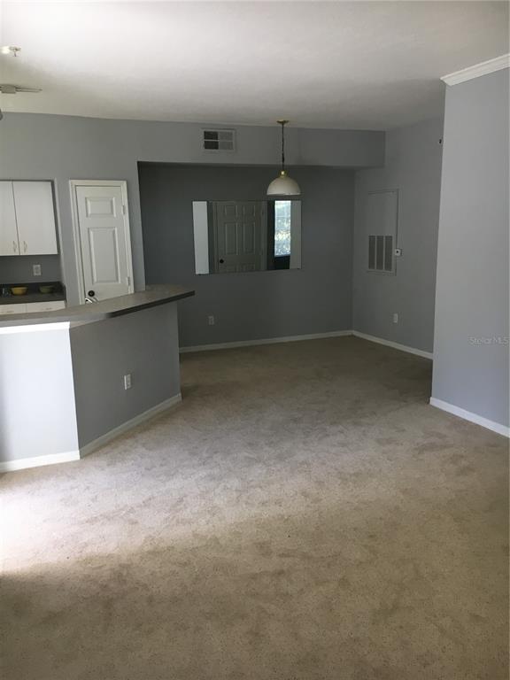 6304 Raleigh Street, Unit 204 Orlando, FL 32835 - Photo 12 of 29 an empty room with kitchen view and windows