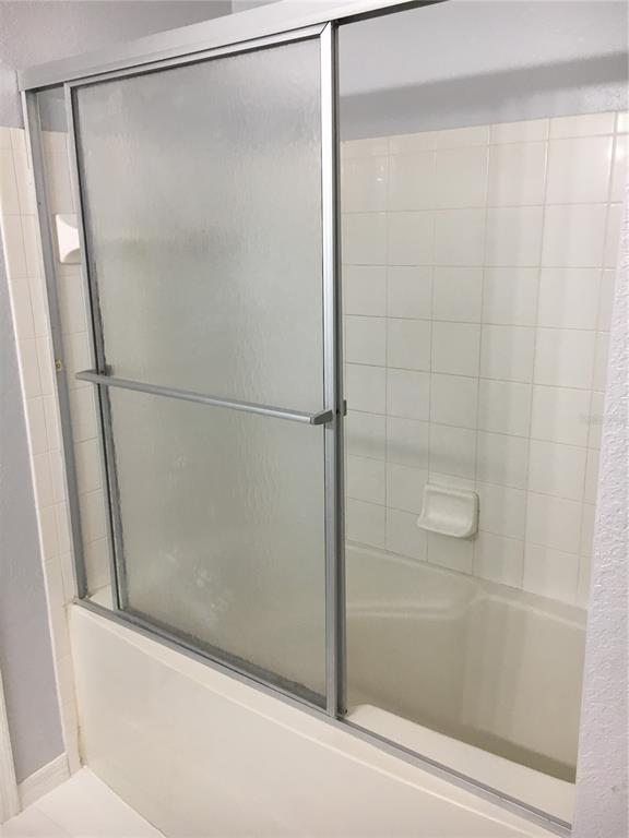 6304 Raleigh Street, Unit 204 Orlando, FL 32835 - Photo 19 of 29 a bathroom with a glass shower door