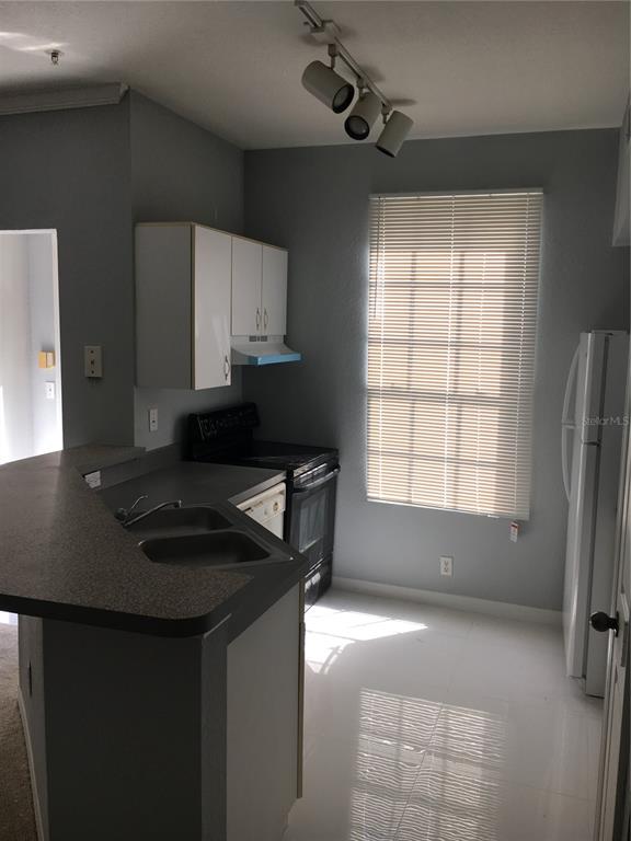 6304 Raleigh Street, Unit 204 Orlando, FL 32835 - Photo 8 of 29 a kitchen with granite countertop a sink a stove and a refrigerator