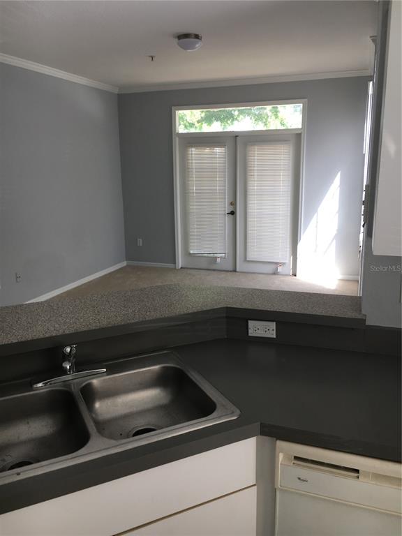6304 Raleigh Street, Unit 204 Orlando, FL 32835 - Photo 9 of 29 a kitchen with a sink and cabinets