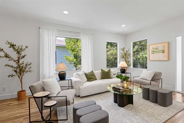 a living room with furniture potted plant and large window