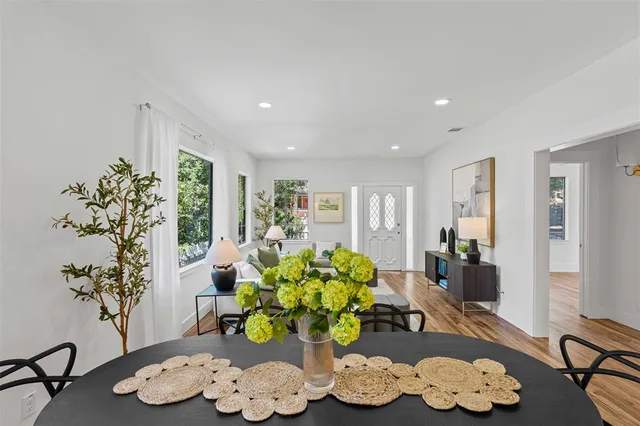 a living room with furniture flowers and a potted plant