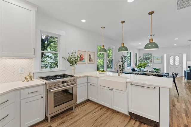 a kitchen with stainless steel appliances granite countertop a stove a sink and a wooden floors