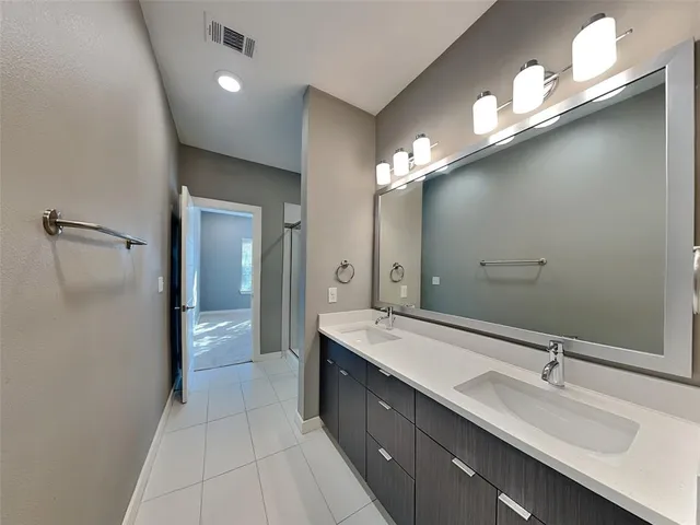 a spacious bathroom with a double vanity sink and a mirror