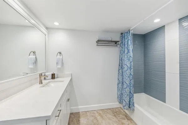 a bathroom with a tub sink and shower