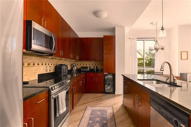 a kitchen with stainless steel appliances granite countertop a stove sink microwave and refrigerator