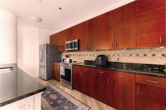 a kitchen with stainless steel appliances granite countertop a refrigerator stove and sink