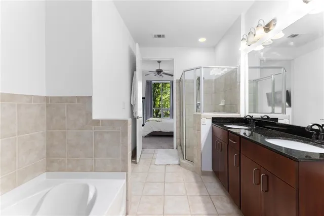 a bathroom with a granite countertop sink a toilet a mirror and bathtub