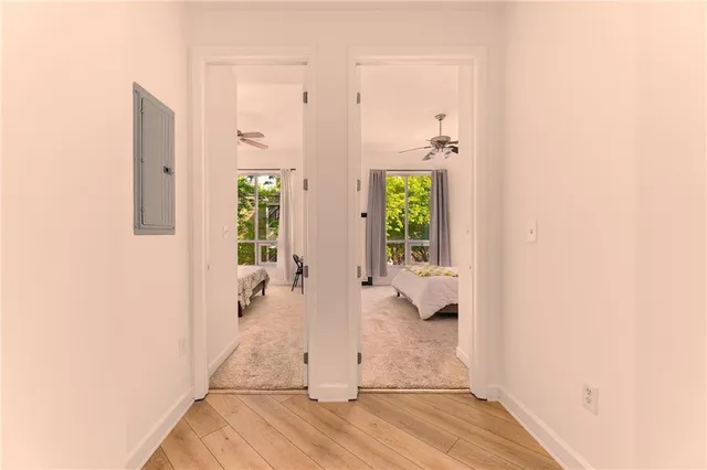 a view of a hallway with wooden floor and a potted plant