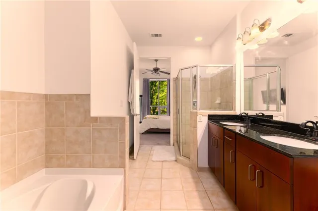 a bathroom with a granite countertop sink a toilet and shower