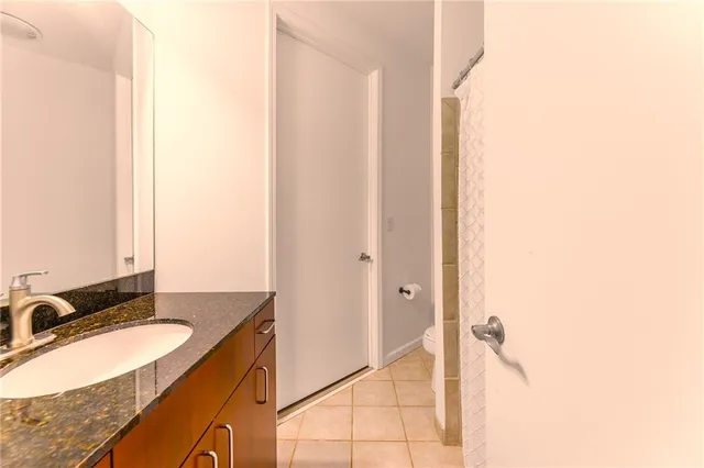 a bathroom with a granite countertop sink and a mirror