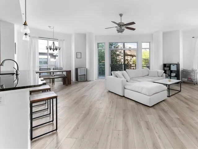 a living room with furniture a window and a ceiling fan