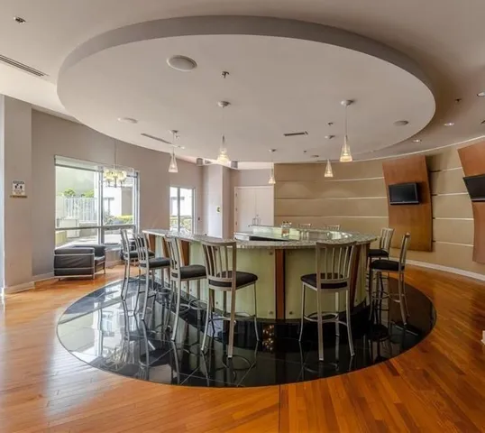 a dining hall with stainless steel appliances a dining table chairs and a large window