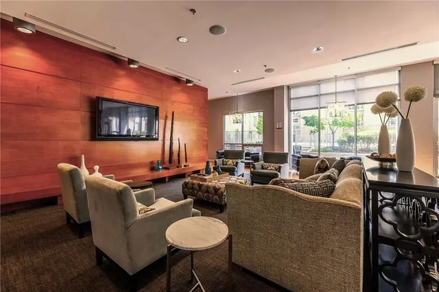 a living room with furniture a large window and a flat screen tv