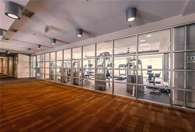 a room with lots of white furniture and a large window