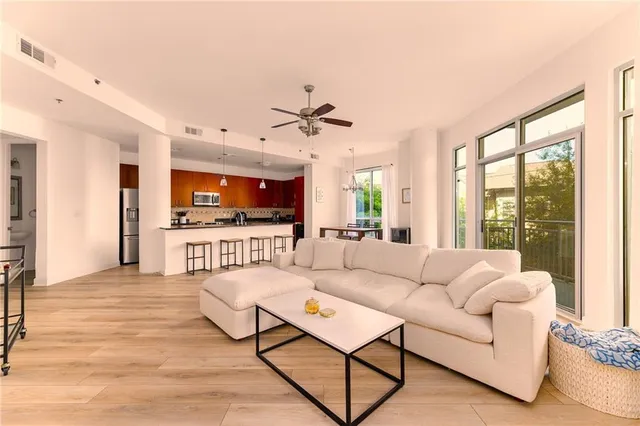 a living room with furniture a floor to ceiling window and a flat screen tv