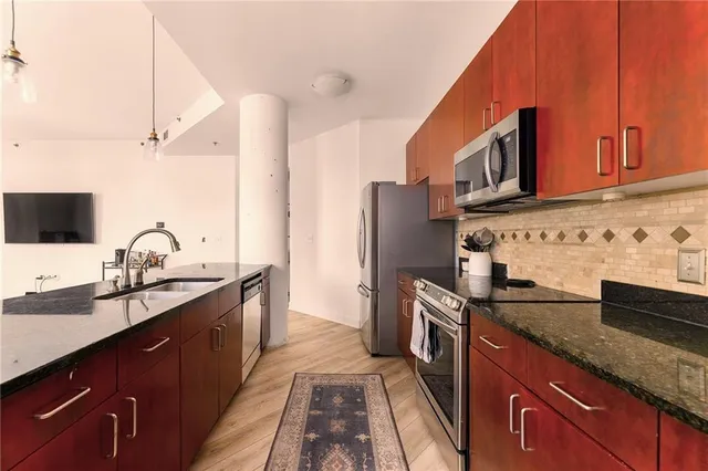 a kitchen with stainless steel appliances granite countertop a sink stove and refrigerator