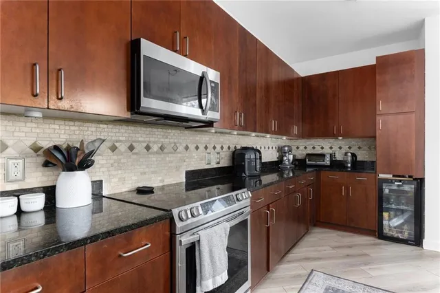 a kitchen with stainless steel appliances granite countertop a sink stove and microwave