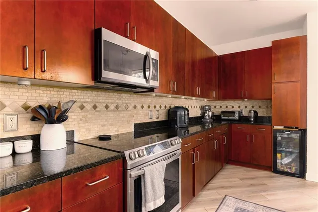 a kitchen with stainless steel appliances granite countertop a sink stove and microwave
